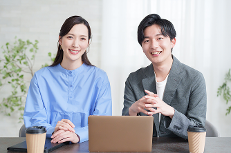 パソコンを前に話すプロジェクトメンバー