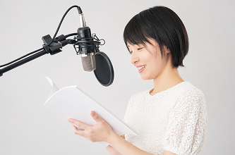 マイクの前で台本を読む声優